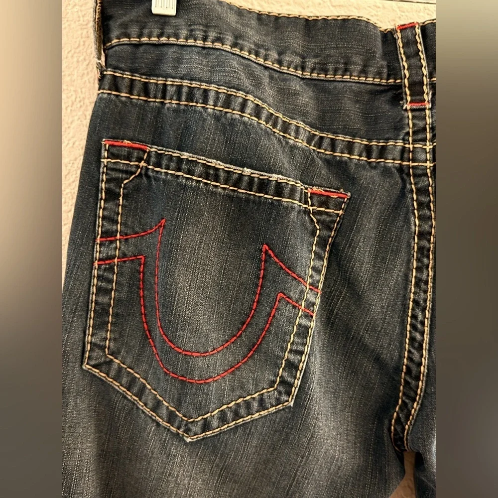 True Religion jeans feature a dark wash and bold signature stitching. Skinny